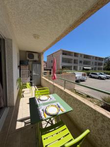 a patio with a table and chairs on a balcony at Studio en plein cœur de Saint Florent in Saint-Florent