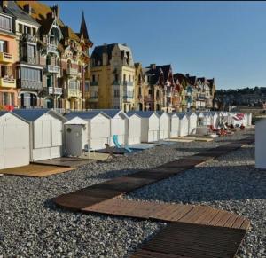 a row of white fences on a beach with buildings at La Villa Turquoise in Le Tréport