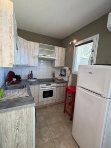 a kitchen with a white refrigerator and a sink at Studio en plein cœur de Saint Florent in Saint-Florent