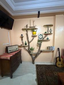 a room with a tree branch on the wall at Gaia guest house in Taghazout