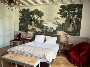 a bedroom with a bed and a painting on the wall at Maison D'hôtes Saint-Gildas in Beaufort-en-Vallée