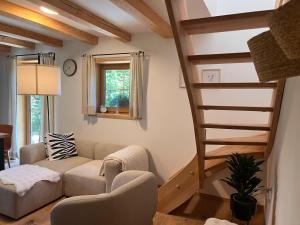 a living room with a staircase and a couch at Lill' Hill estate & wellness - Lumina Chalet in Idrija