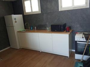 a kitchen with a white counter and a refrigerator at North Station Residence Beer Sheva in Beer Sheva