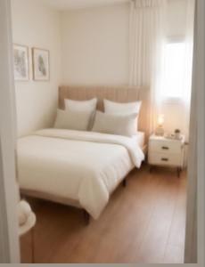 a bedroom with a large white bed and a window at North Station Residence Beer Sheva in Beer Sheva