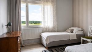 a bedroom with a bed and a window at Cozy apartment with sauna in Haapavesi