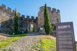 an old castle with a sign in front of it at Casa dos Malmequeres - Alegrete in Portalegre