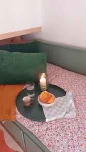 a tray with a candle and a plate on a bed at Casa dos Malmequeres - Alegrete in Portalegre