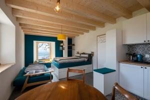 a small room with two beds and a table at Maison d hôtes Les Bruyères in Bonvillars