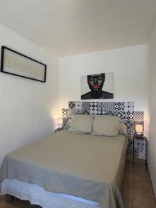 a bedroom with a bed with a black face on the wall at Studio en plein cœur de Saint Florent in Saint-Florent