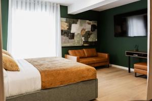 ein Schlafzimmer mit grünen Wänden, einem Bett und einem Stuhl in der Unterkunft Boutique rooms Vis Adults only in Vis