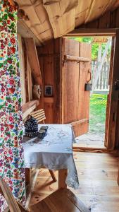 a room with a table in a cabin with an open door at Zaścianek Roztocze in Chłopków