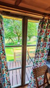 a screened in porch with a chair and a window at Zaścianek Roztocze in Chłopków +7 photos
