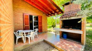 a patio with a table and chairs and a fireplace at Aromas del Mediterraneo Casa de Montaña 2 in Arroyo de Los Patos