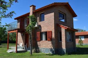 a brick house with a balcony on the side of it at Aromas del Mediterraneo Casa de Montaña 2 in Arroyo de Los Patos