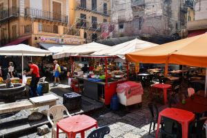 an outdoor market with tables and chairs and umbrellas at La Dimora di Alba in Palermo