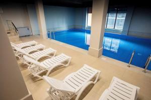 a row of white chairs in front of a pool at Mar y Sol in Batumi