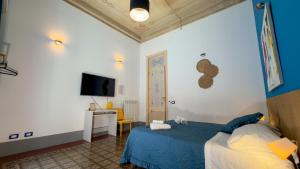 a bedroom with a bed and a desk and a tv at La Dimora di Alba in Palermo