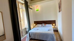 a bedroom with a bed and a large window at La Dimora di Alba in Palermo