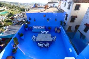 an overhead view of a blue balcony with a table and chairs at Casa Raselma - Rela Mountains & Spectacular Views in Chefchaouen