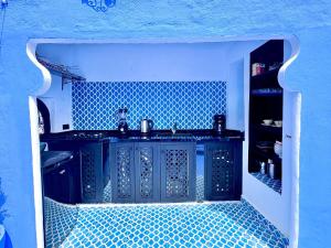 a blue kitchen with a sink and a blue wall at Casa Raselma - Rela Mountains & Spectacular Views in Chefchaouen
