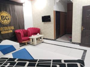 a room with two chairs and a table and a door at Shelton Royal Hotel in Multan +36 photos
