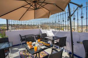 a patio with tables and chairs and an umbrella at Riad Mozaik Fes in Fez