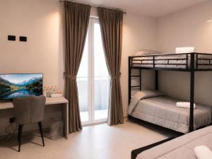 ein Schlafzimmer mit zwei Etagenbetten, einem Schreibtisch und einem Computer in der Unterkunft Hotel Genesis in Vignola