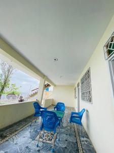 a patio with four blue chairs and a table at Murree Sky Heights in Khaira Gali