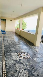 a room with a tile floor with a blue chair at Murree Sky Heights in Khaira Gali +4 photos