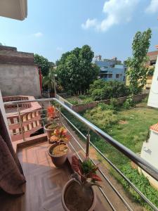 a balcony with three potted plants on a roof at Bhakti Suite in Deoghar