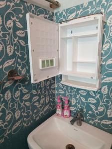 a bathroom with a sink and a cabinet above a sink at Bhakti Suite in Deoghar +26 photos
