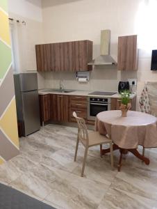 a kitchen with a table and a stove and a refrigerator at NJ Stay Gozo in Għajnsielem +6 photos