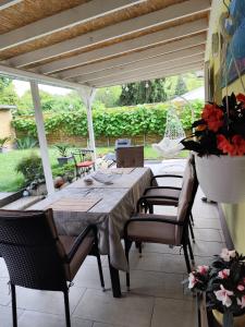 a patio with a table and chairs under a pergola at Niki Vendégház in Abaliget