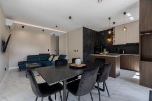 a kitchen and living room with a table and chairs at Marina Dziwnow Premium Haus in Dziwnów +14 photos