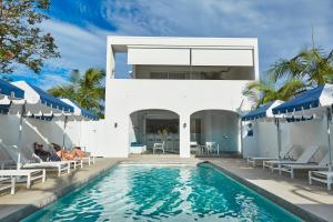 a villa with a swimming pool and a house at The Sails Motel Brunswick Heads in Brunswick Heads