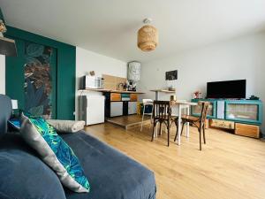 a living room with a couch and a table with chairs at Mon petit cocon auvergnat in Combronde