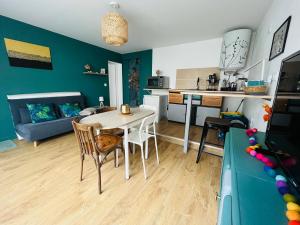 a kitchen and living room with a table and a couch at Mon petit cocon auvergnat in Combronde
