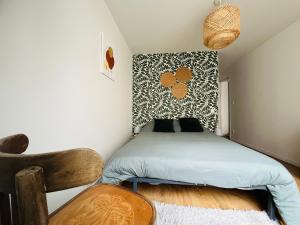 a small bedroom with a bed and a chair at Mon petit cocon auvergnat in Combronde