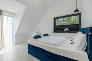 a white bed in a room with a window at Marina Dziwnow Premium Haus in Dziwnów