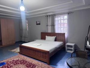 a bedroom with a bed and a window at Guyana Guest House in Naivasha