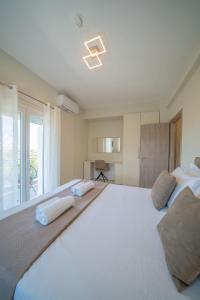 a large white bedroom with a large bed with two pillows at Gerania nature Residence 21 in Siátista