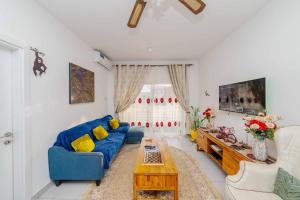 a living room with a blue couch and a table at Zanzibar,Fumbatown 2 Bed Ocean view Apartment in Fumba