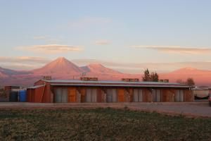 an old building with a mountain in the background at Eltoconar atacama in San Pedro de Atacama +15 photos