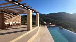 a house with a swimming pool with mountains in the background at Casa La Petite in San Pantaleo