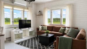 a living room with a couch and a flat screen tv at Maalaistalo maatilamiljöössä in Haapavesi