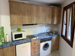 a small kitchen with a microwave and a stove at Casa Chica in Cazorla