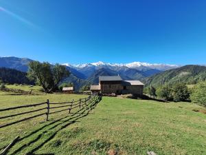 a barn in a field with mountains in the background at Heshklar guest house in Keshkili