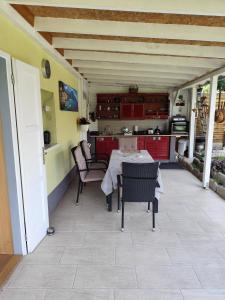 a kitchen and dining room with a table and chairs at Niki Vendégház in Abaliget +18 photos