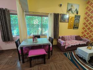a living room with a table and a couch at Bhakti Suite in Deoghar