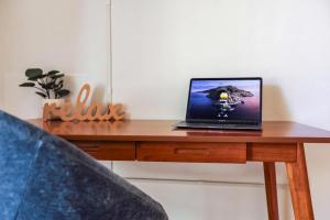 a laptop computer sitting on a wooden desk at The YinYang - King Bed , Workspace , Full Kitchen in Gainesville